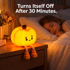 A glowing pumpkin-shaped night light with a sad face and rope legs sits on a wooden bedside table in a bedroom. A child is sleeping in bed in the background, and white text at the top reads, 'Turns Itself Off After 30 Minutes.